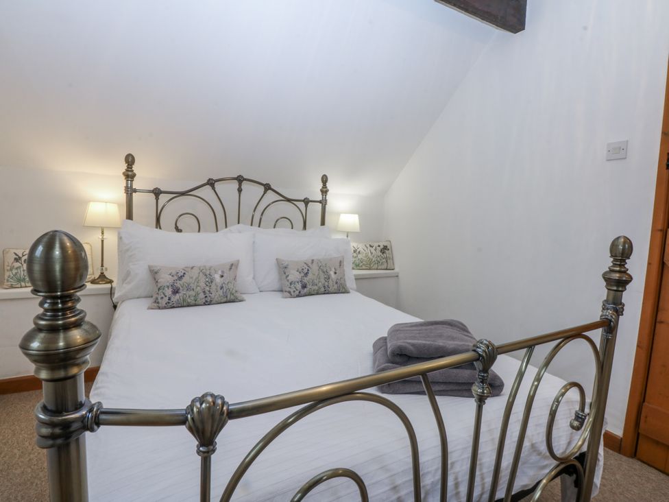 A bedroom with a bed and bedside lamps at Ty Gwennol in Llanfaethlu