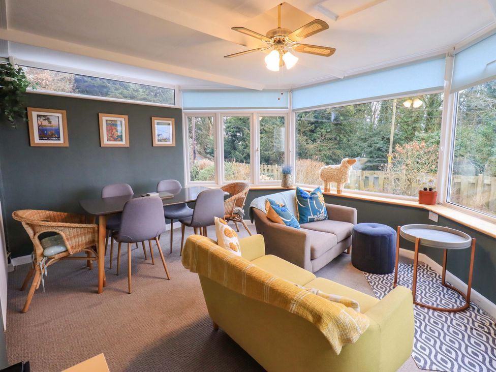 A conservatory with seating and dining area at Yewbarrow Cottage in Grange-Over-Sands