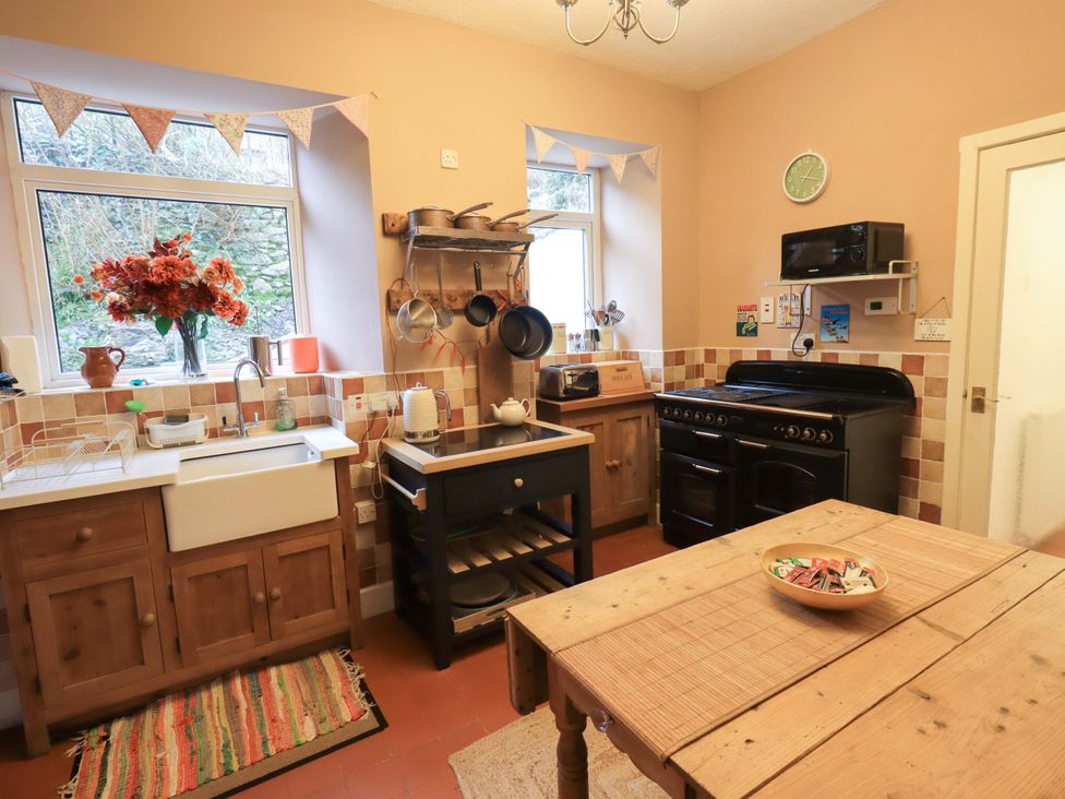 A kitchen with a sink and an oven at Yewbarrow Cottage in Grange-Over-Sands