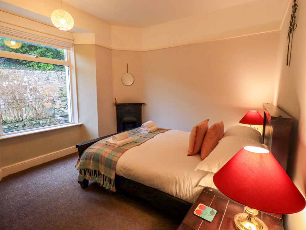 A bedroom with a bed and window at Yewbarrow Cottage in Grange-Over-Sands