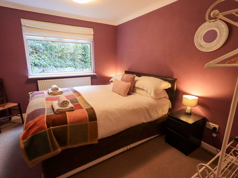 A bedroom with a bed and bedside table at Yewbarrow Cottage in Grange-Over-Sands