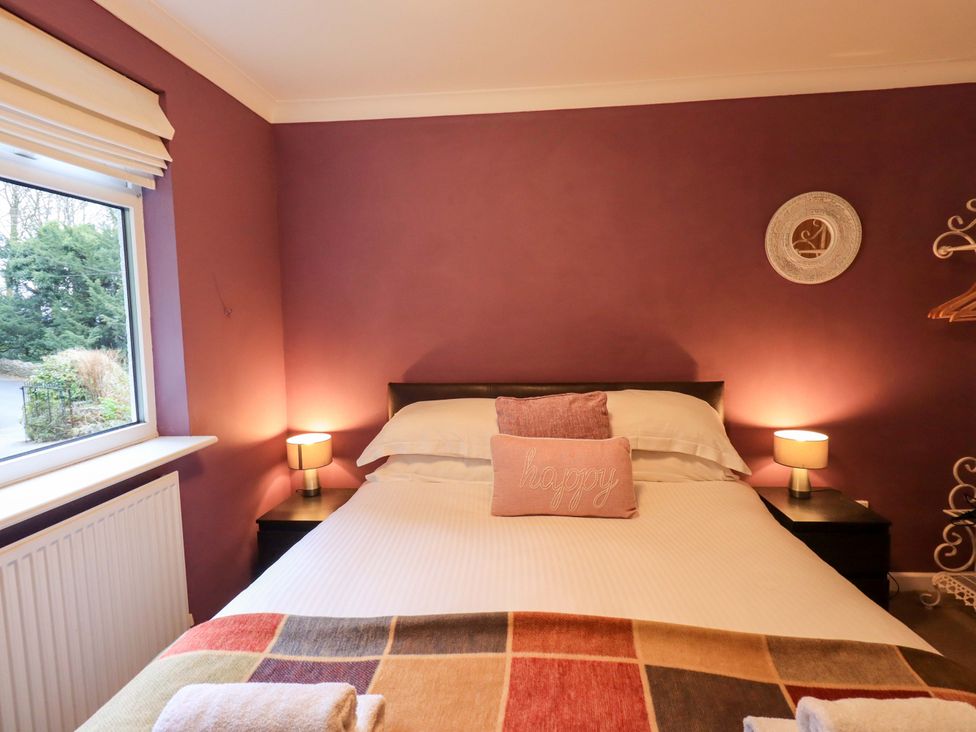 A bedroom with a bed and a window at Yewbarrow Cottage in Grange-Over-Sands