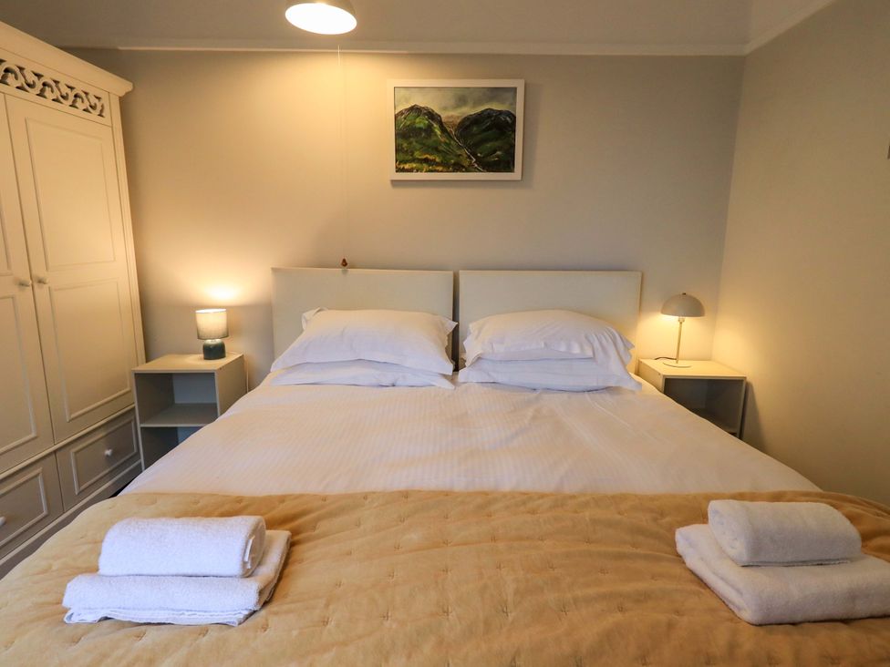 A bedroom with a bed and bedside tables at Yewbarrow Cottage Grange-Over-Sands