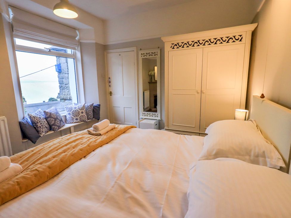A bedroom with a bed and wardrobe at Yewbarrow Cottage in Grange-Over-Sands