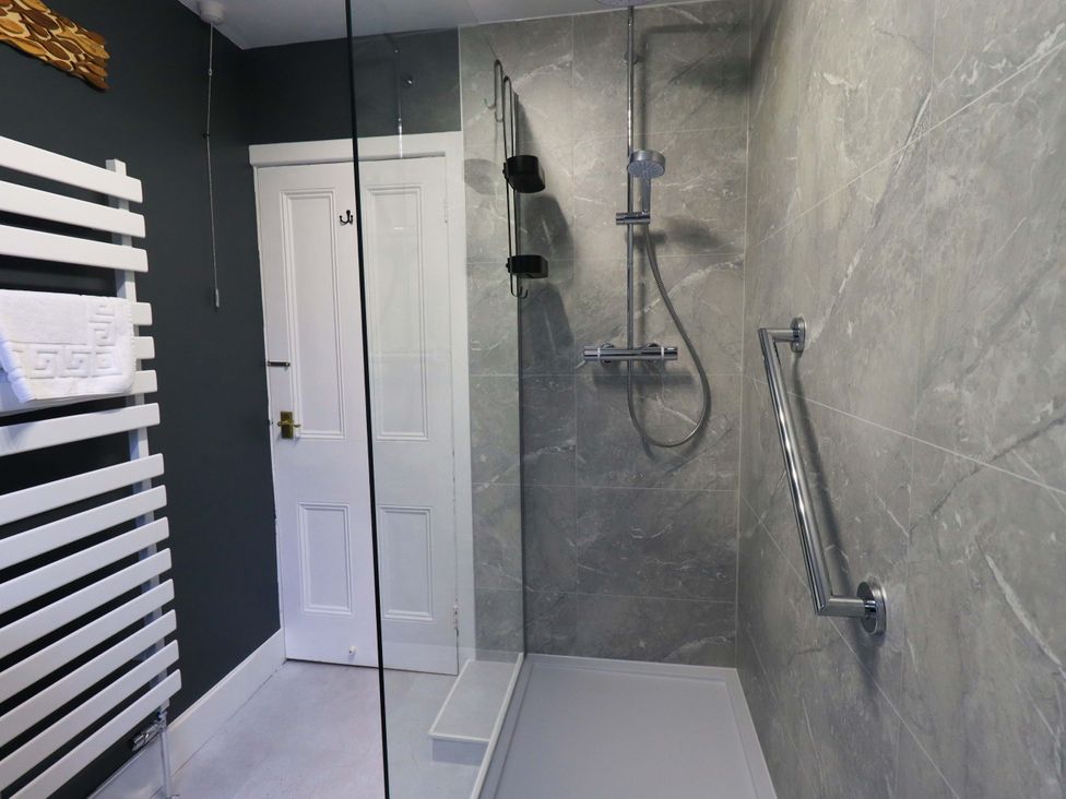 A bathroom with a shower and towel rail at Yewbarrow Cottage in Grange-Over-Sands