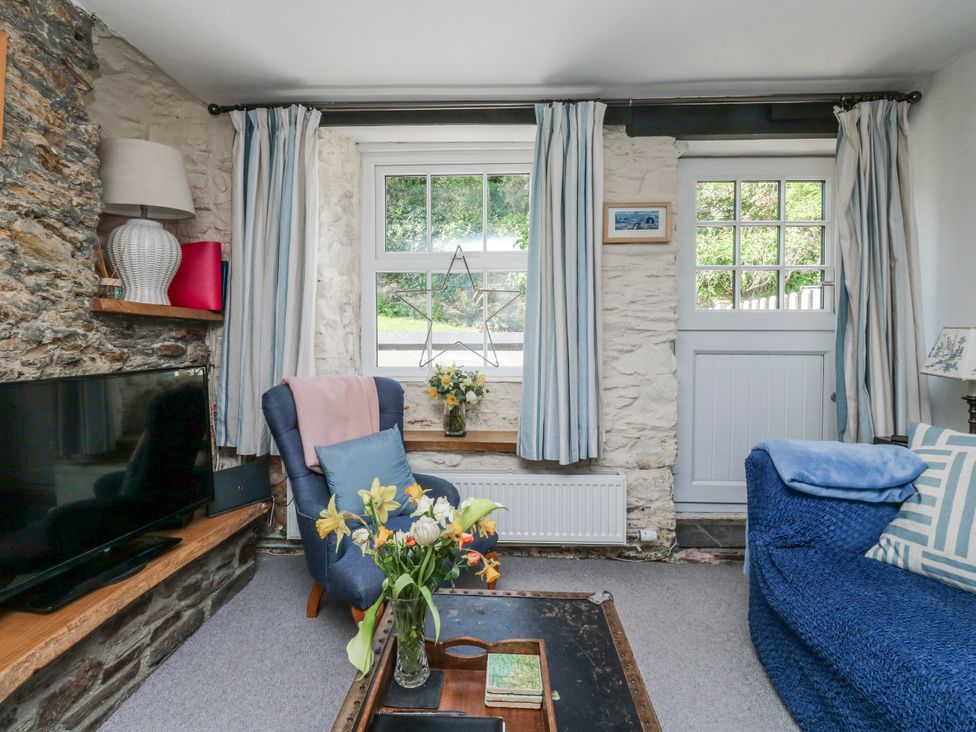 A living room with a television and sofa at 3 Rock Cottages in Kingston