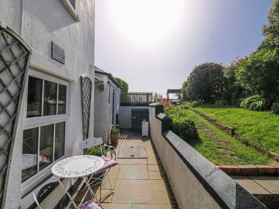 A patio area with a table and chairs at 3 Rock Cottages Kingston