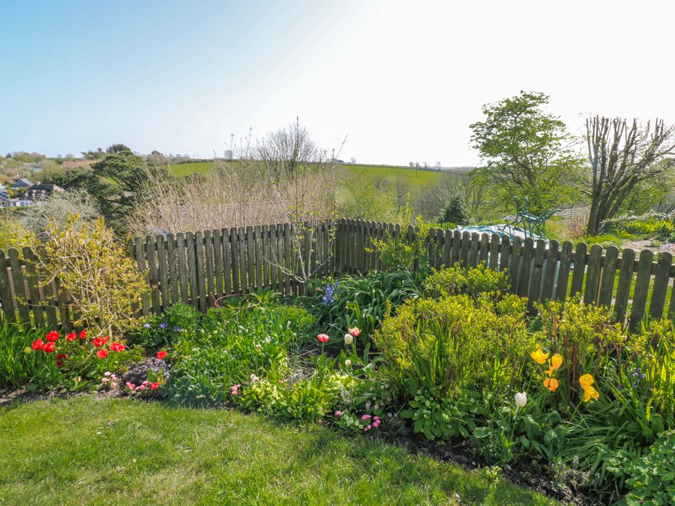 A garden with flowers and a wooden fence at 3 Rock Cottages in Kingston