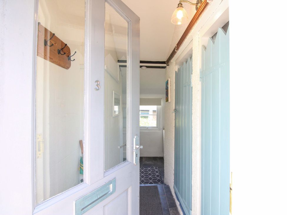 A hallway with hooks and a light fixture at 3 Rock Cottages Kingston
