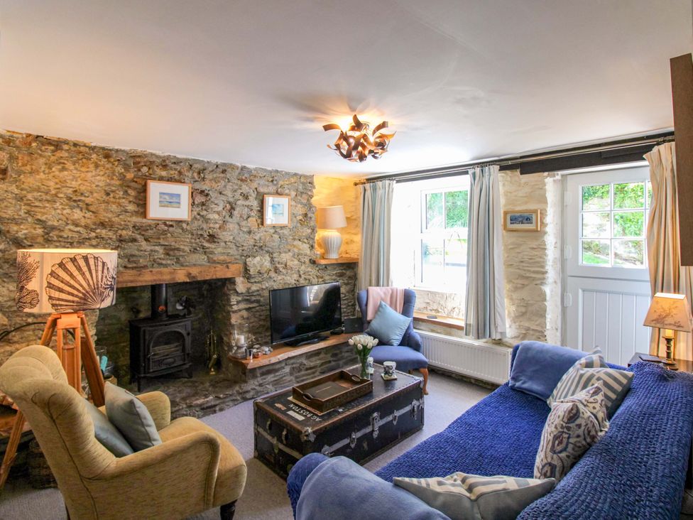 A living room with a fireplace and television at 3 Rock Cottages in Kingston