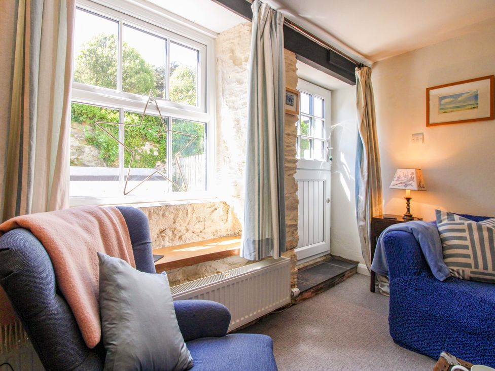 A living room with an armchair and a sofa at 3 Rock Cottages in Kingston