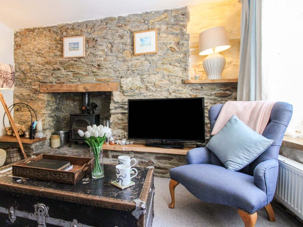 A living room with a stone wall and fireplace at 3 Rock Cottages in Kingston