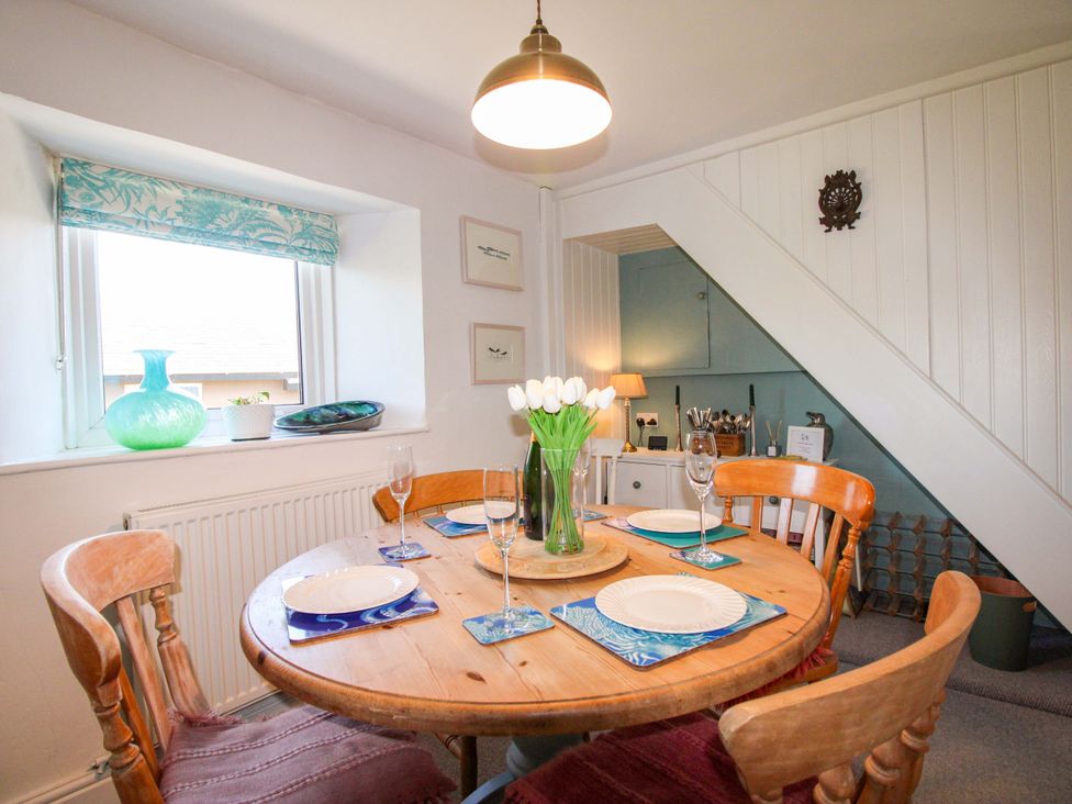 A dining room with a table set for meals at 3 Rock Cottages Kingston
