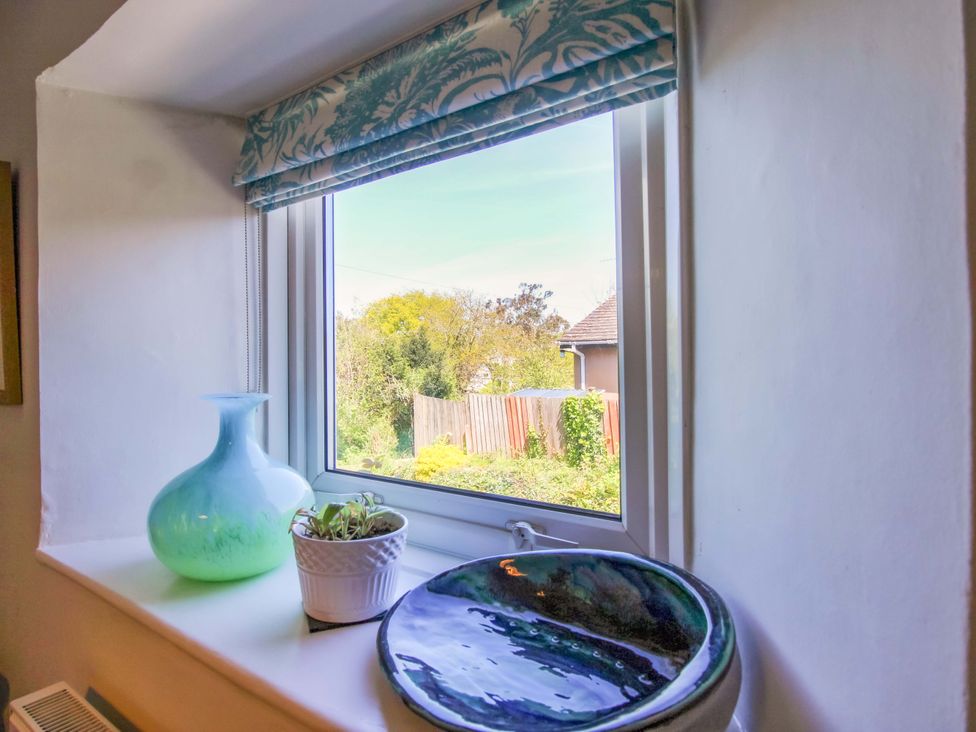 A window with a green vase and white pot on the sill at 3 Rock Cottages Kingston