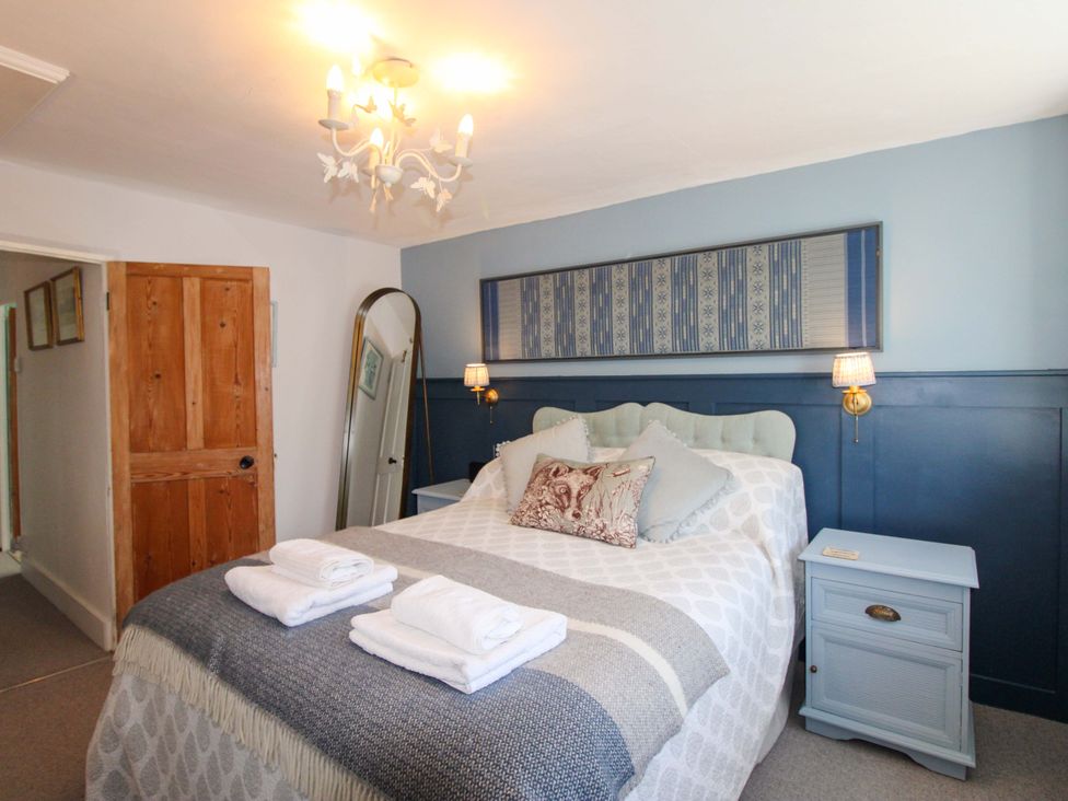 A bedroom with a bed and bedside table at 3 Rock Cottages in Kingston