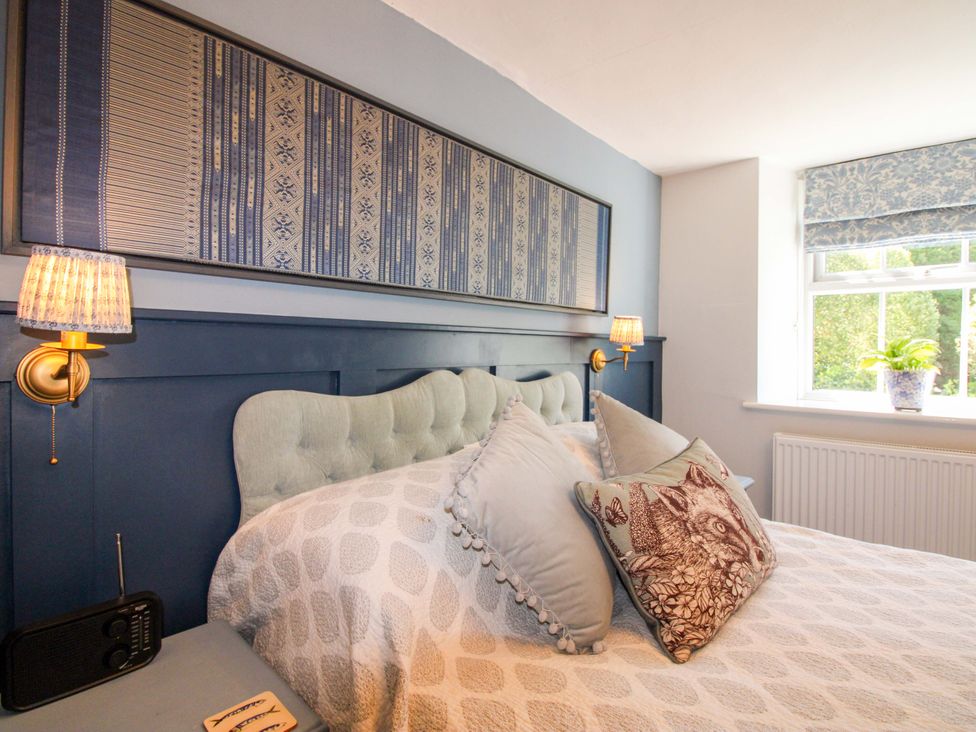 A bedroom with a bed and decorative pillows at 3 Rock Cottages in Kingston
