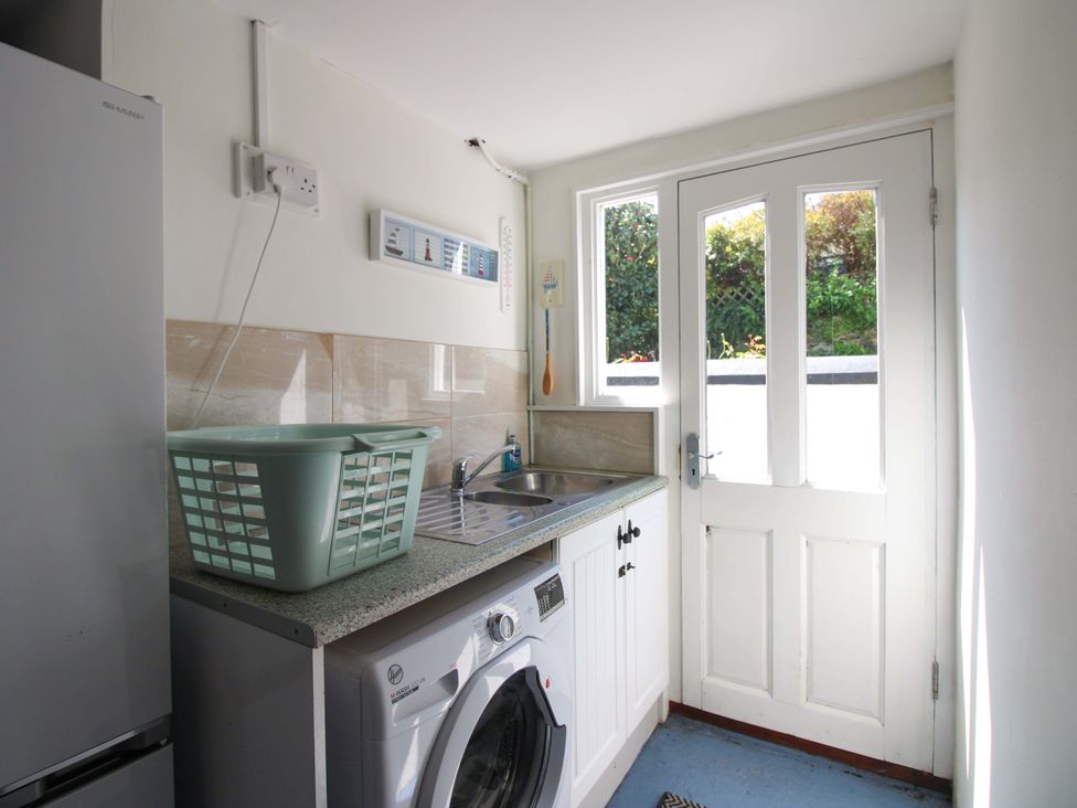 A laundry room with washing machine and sink at 3 Rock Cottages in Kingston