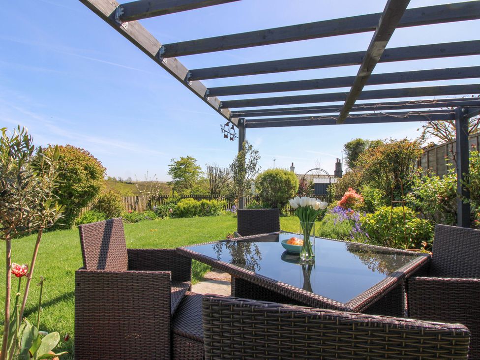 A garden with a dining table and chairs at 3 Rock Cottages Kingston
