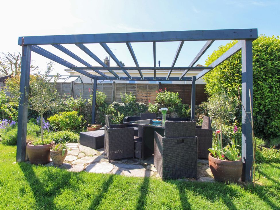 A garden with a seating area under a pergola at 3 Rock Cottages Kingston