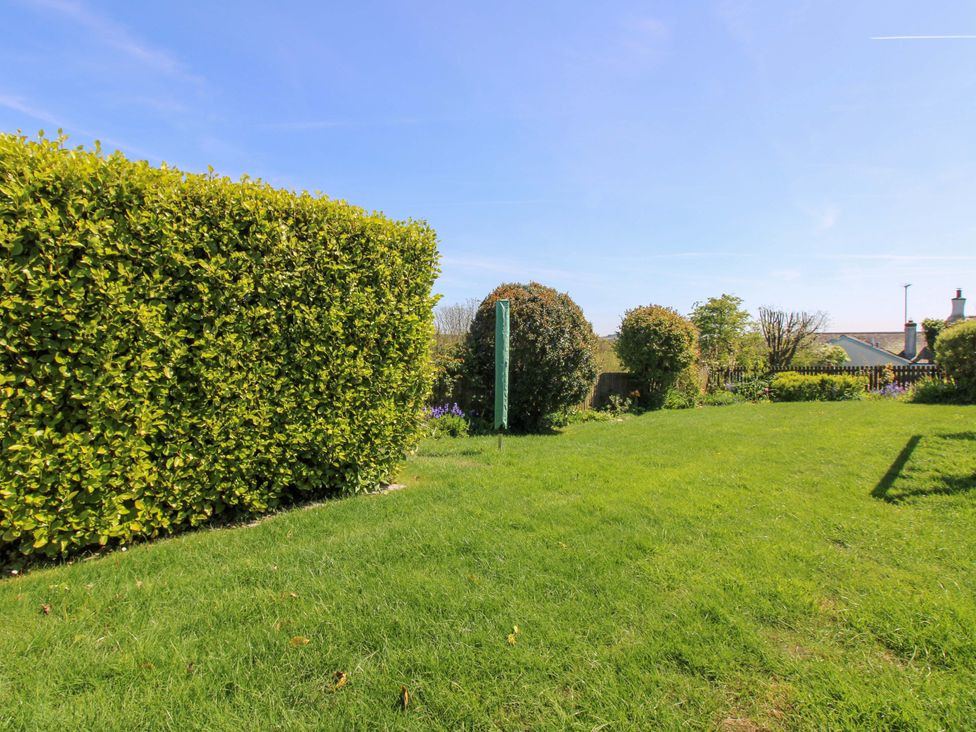 A garden with grass and hedges at 3 Rock Cottages Kingston