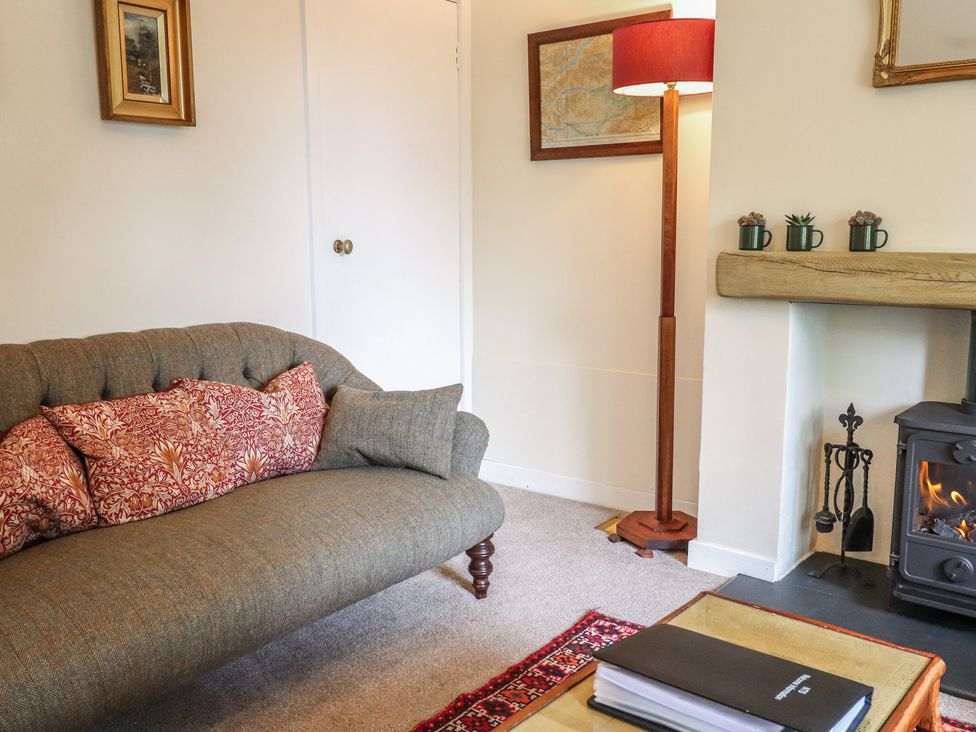 A living room with a sofa and a fireplace at Branklyn Garden Cottage in Perth