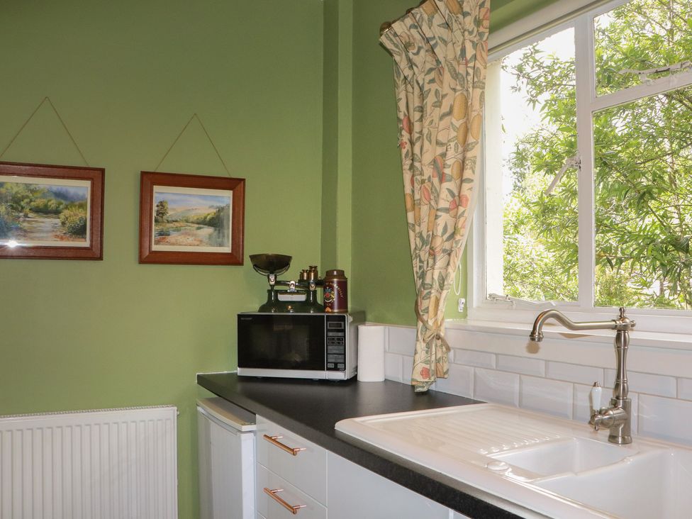 A kitchen area with a sink and microwave at Branklyn Garden Cottage in Perth