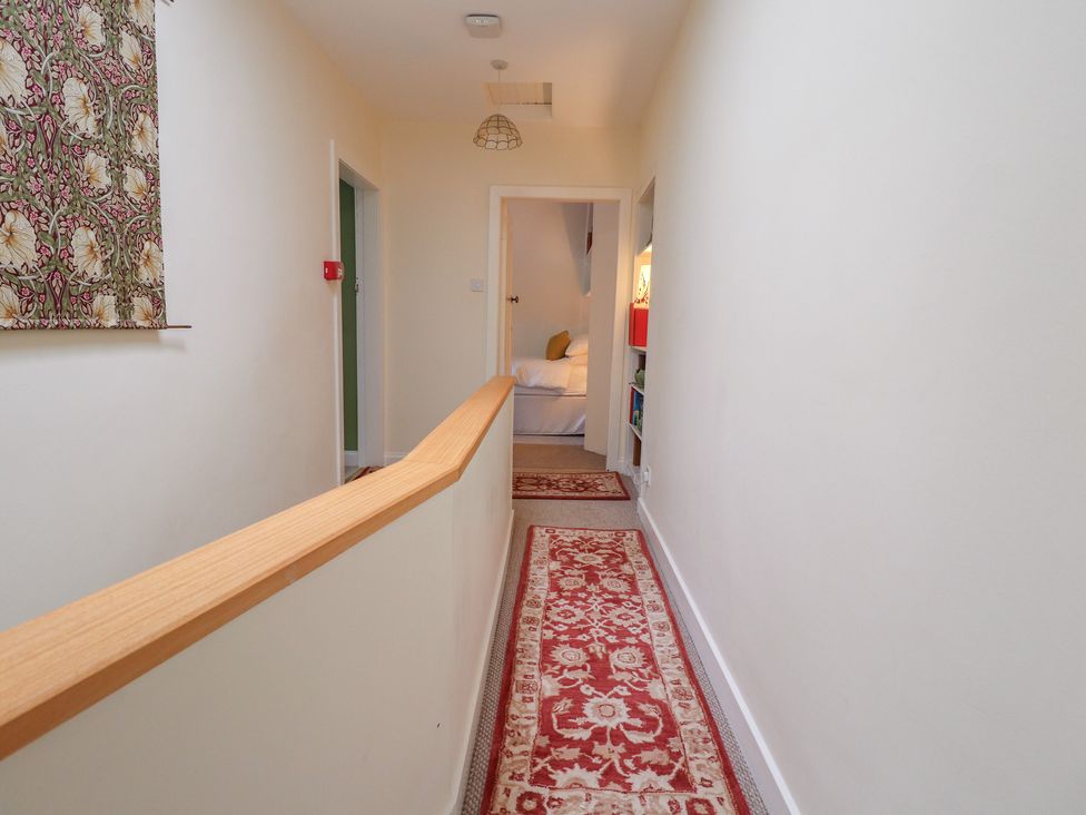 A hallway with carpet and doors at Branklyn Garden Cottage in Perth