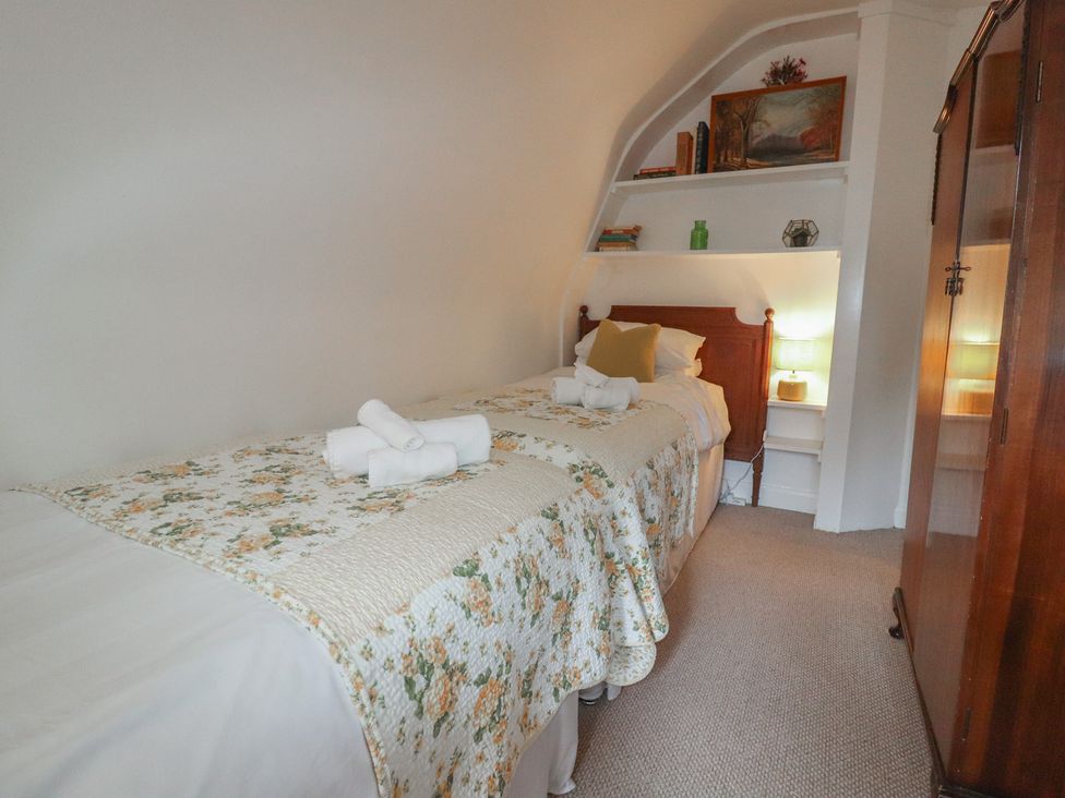 A bedroom with two beds and a wardrobe at Branklyn Garden Cottage in Perth