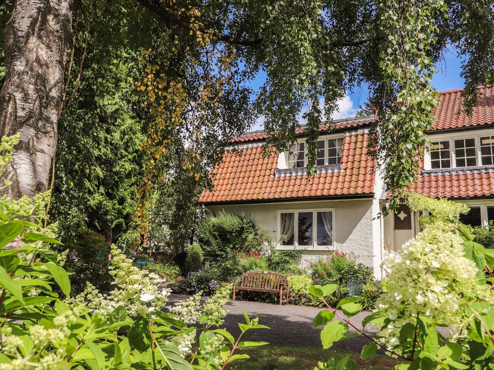 A house with a garden and bench at Branklyn Garden Cottage in Perth