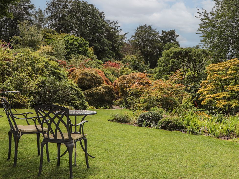 A garden with chairs and a table at Branklyn Garden Cottage in Perth