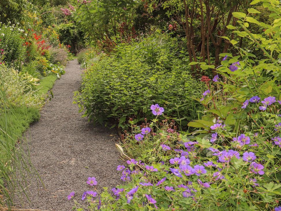 A garden path lined with flowers and plants at Branklyn Garden Cottage in Perth