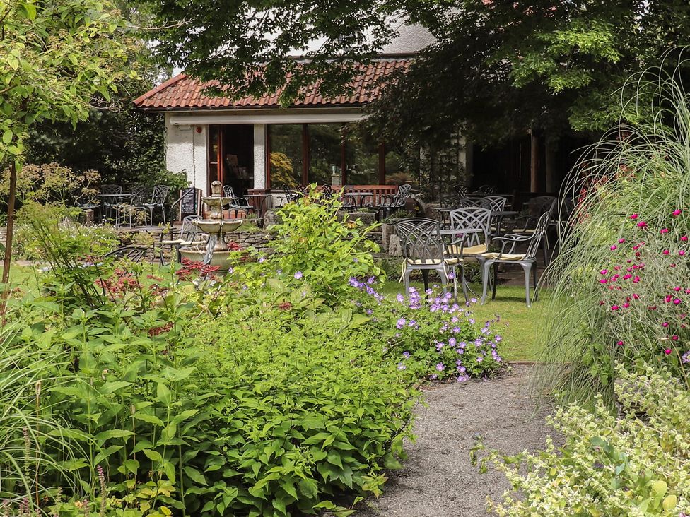 A garden with chairs and tables at Branklyn Garden Cottage in Perth