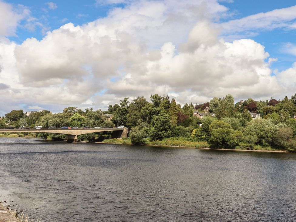 A river with a bridge and trees at Branklyn Garden Cottage in Perth