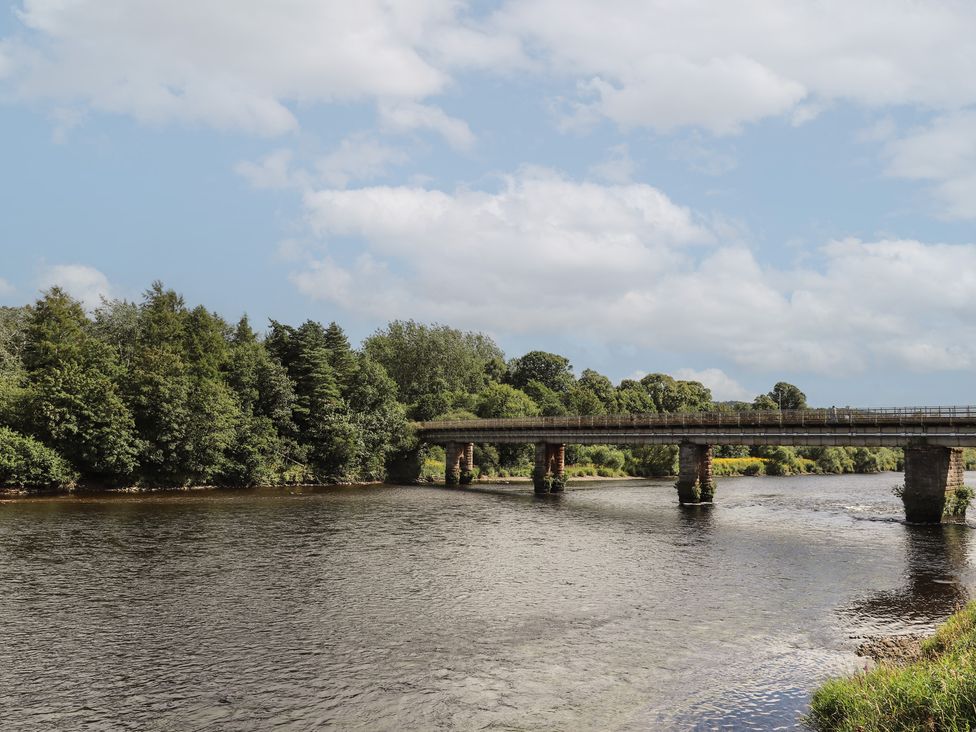 A river with a bridge and trees at Branklyn Garden Cottage in Perth