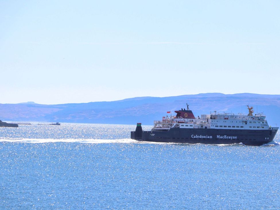 A ferry sailing on the water near hills at Beaton's Croft House - Uig Skye Kilmuir near Uig