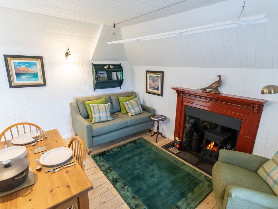 A living room with a sofa and fireplace at Beaton's Croft House - Uig Skye in Kilmuir near Uig