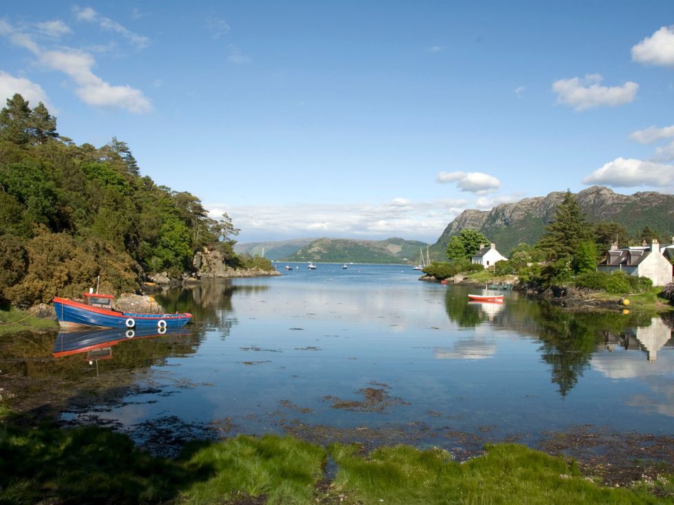 A view of a river with boats and trees at Craggan Cottage - Balmacara Kyle Of Lochalsh