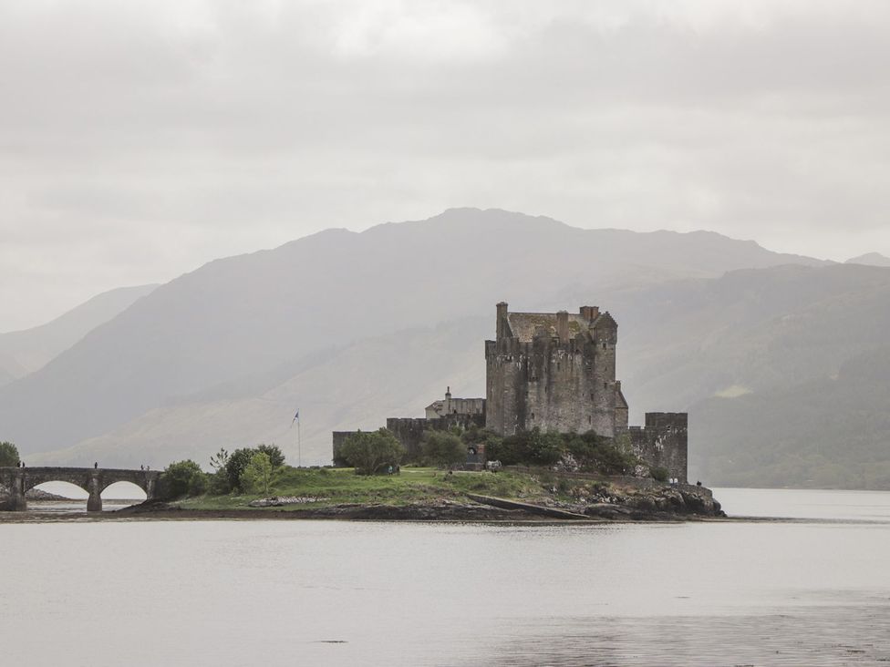 A castle on an island surrounded by water at Ferry Cottage - Balmacara in Kyle Of Lochalsh