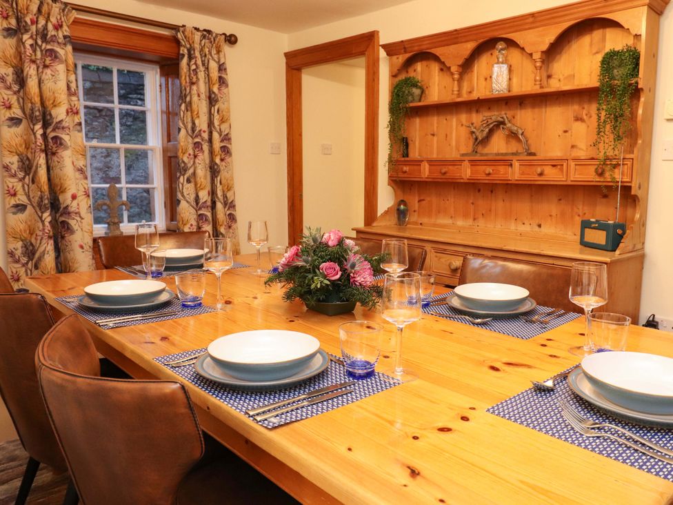 A dining room with a wooden table set for a meal at Paye House - Cromarty
