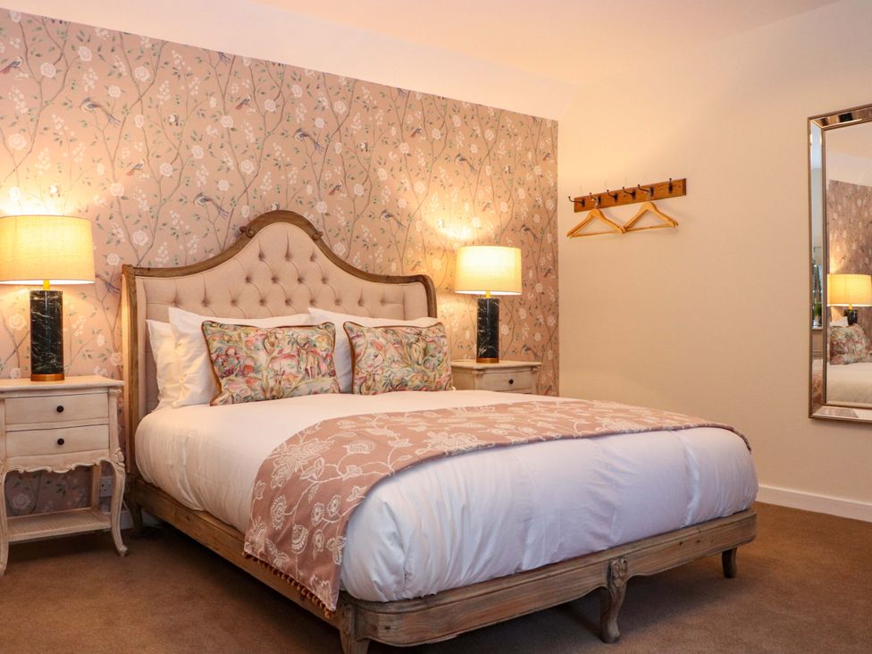 A bedroom with a bed, nightstand, and lamp at Paye House - Cromarty