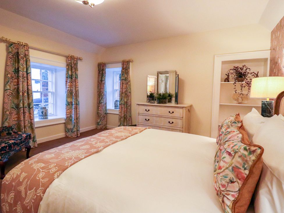 A bedroom with a bed and dressing table at Paye House - Cromarty
