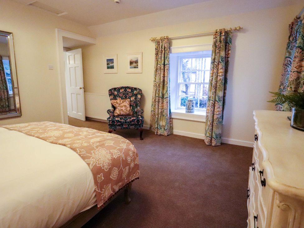 A bedroom with a bed, dresser, and chair at Paye House - Cromarty