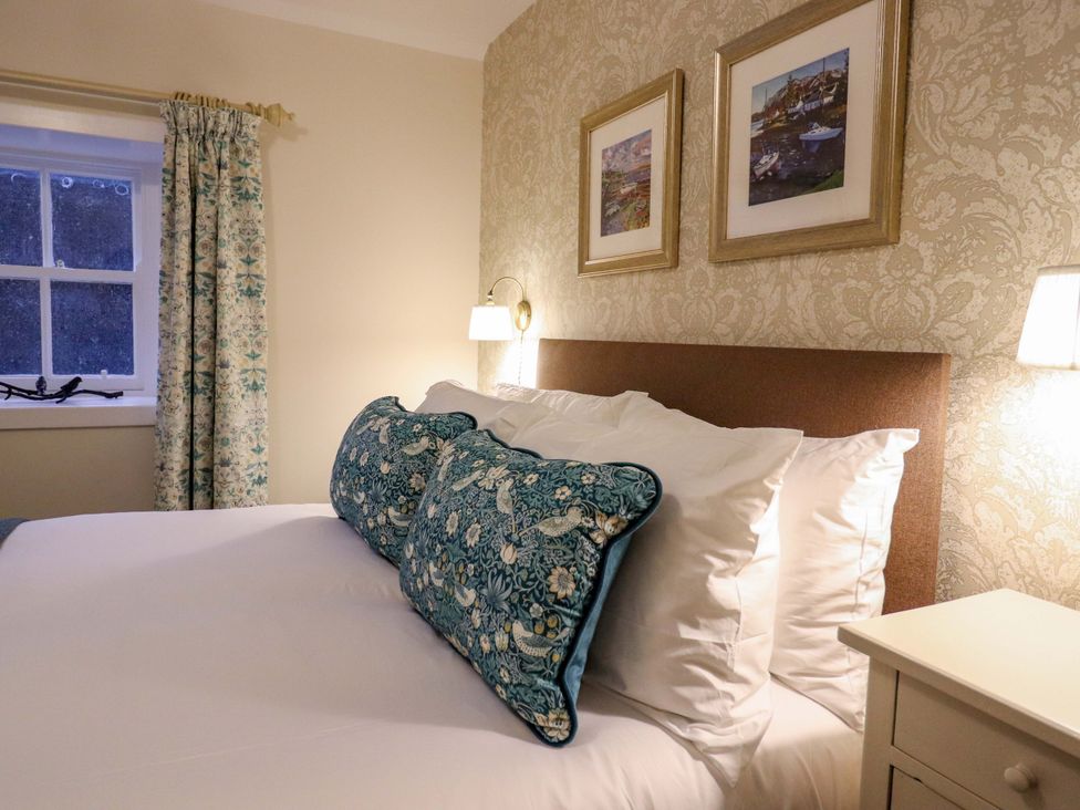 A bedroom with a bed and decorative pillows at Paye House - Cromarty
