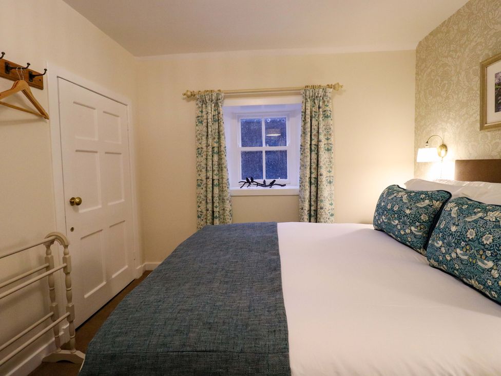 A bedroom with a bed and window at Paye House - Cromarty