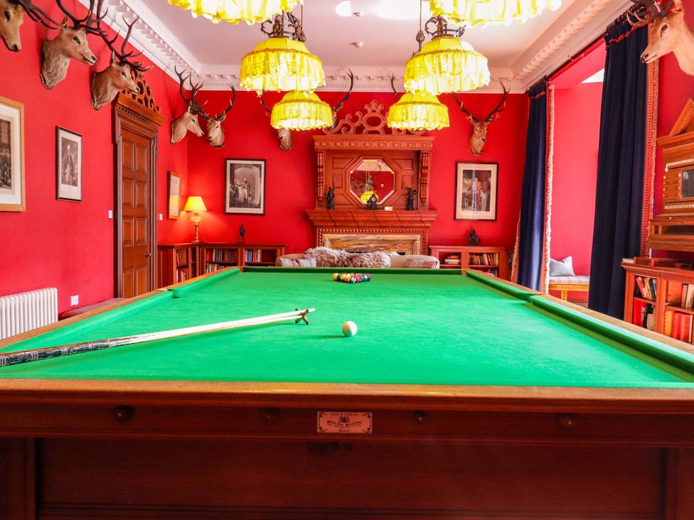 A snooker room with a green table and cues at Paye House - Cromarty