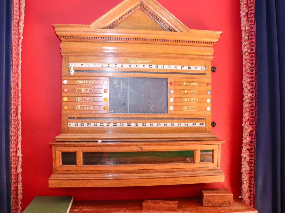 A wooden board game with numbers and colored buttons at Paye House - Cromarty
