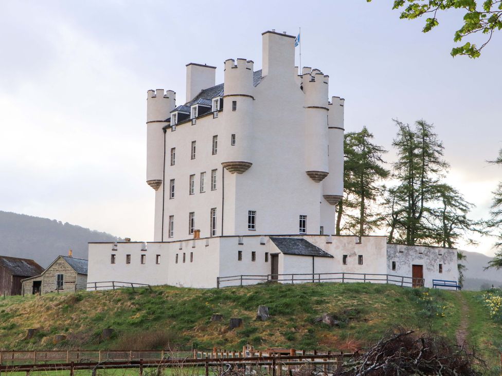 A castle with towers and a surrounding fence at Paye House - Cromarty