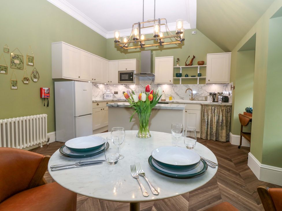 A kitchen with dining area featuring a table and chairs at Braeriach - Mar Lodge Estate in Braemar