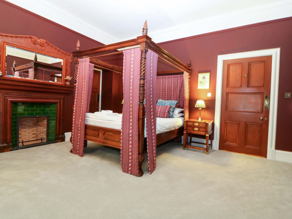 A bedroom with a four-poster bed and a fireplace at Braeriach - Mar Lodge Estate in Braemar