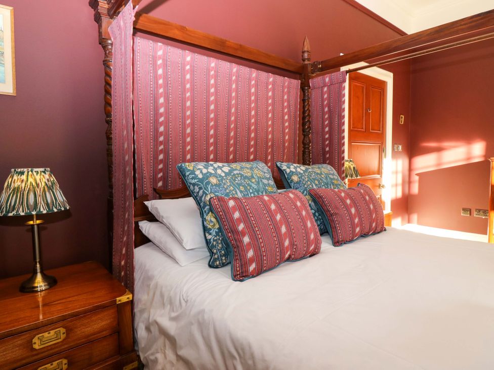 A bedroom with a four-poster bed and bedside lamp at Braeriach - Mar Lodge Estate in Braemar